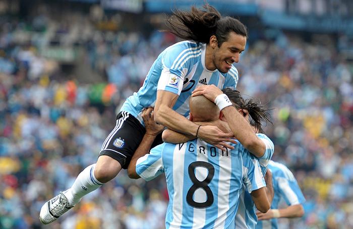 Jonas Gutierrez (top) and Juan Veron of Argentina celebrate the opening goal against Nigeria as the mob goalscorer Gabriel Heinze (hidden)