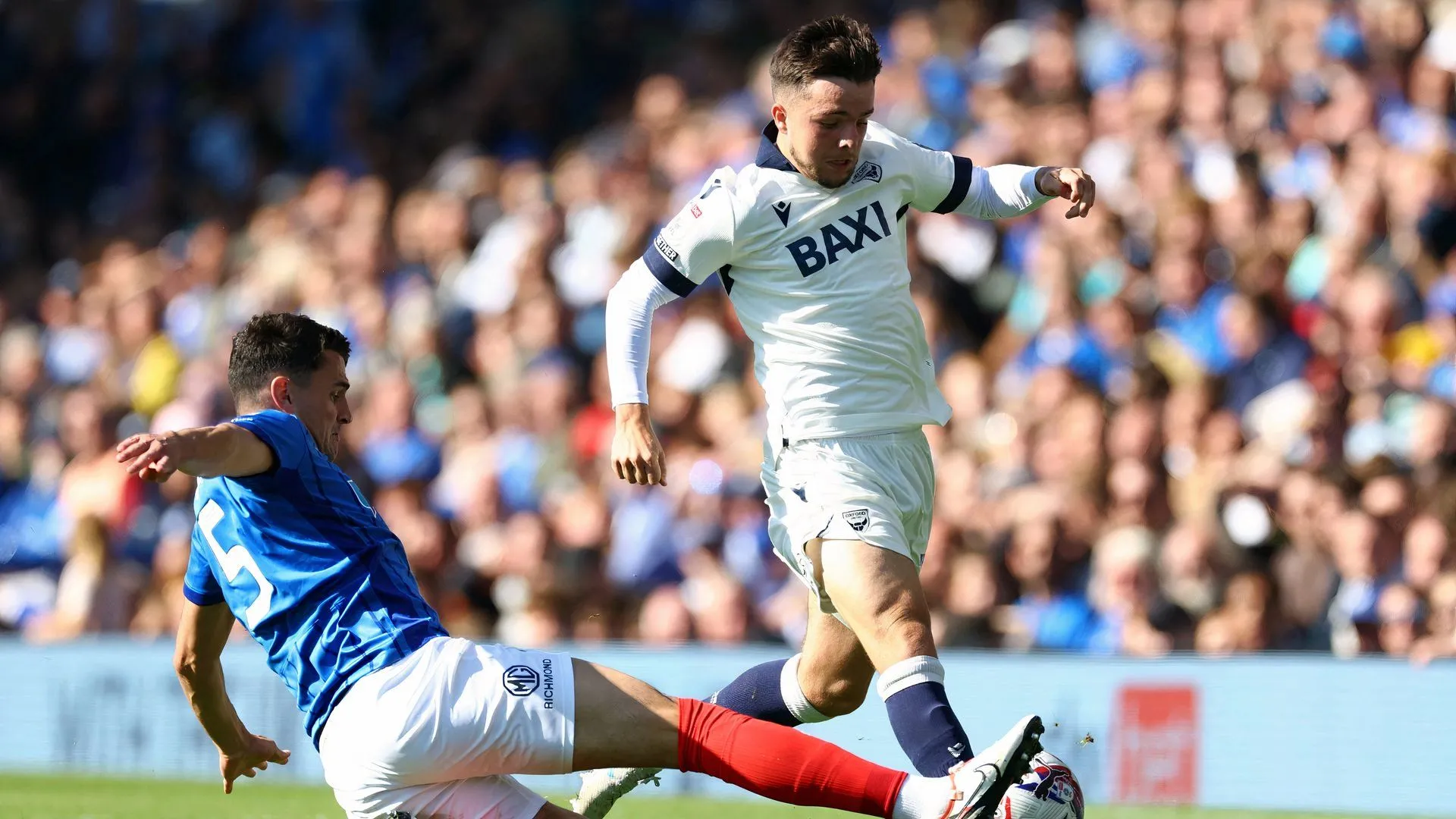 Tyler Goodrham và Regan Poole của Oxford United trên sân cỏ