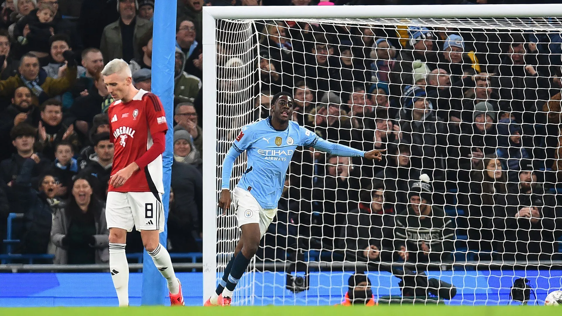 Divin Mubama ăn mừng bàn thắng cho Manchester City trong trận đấu với Salford City