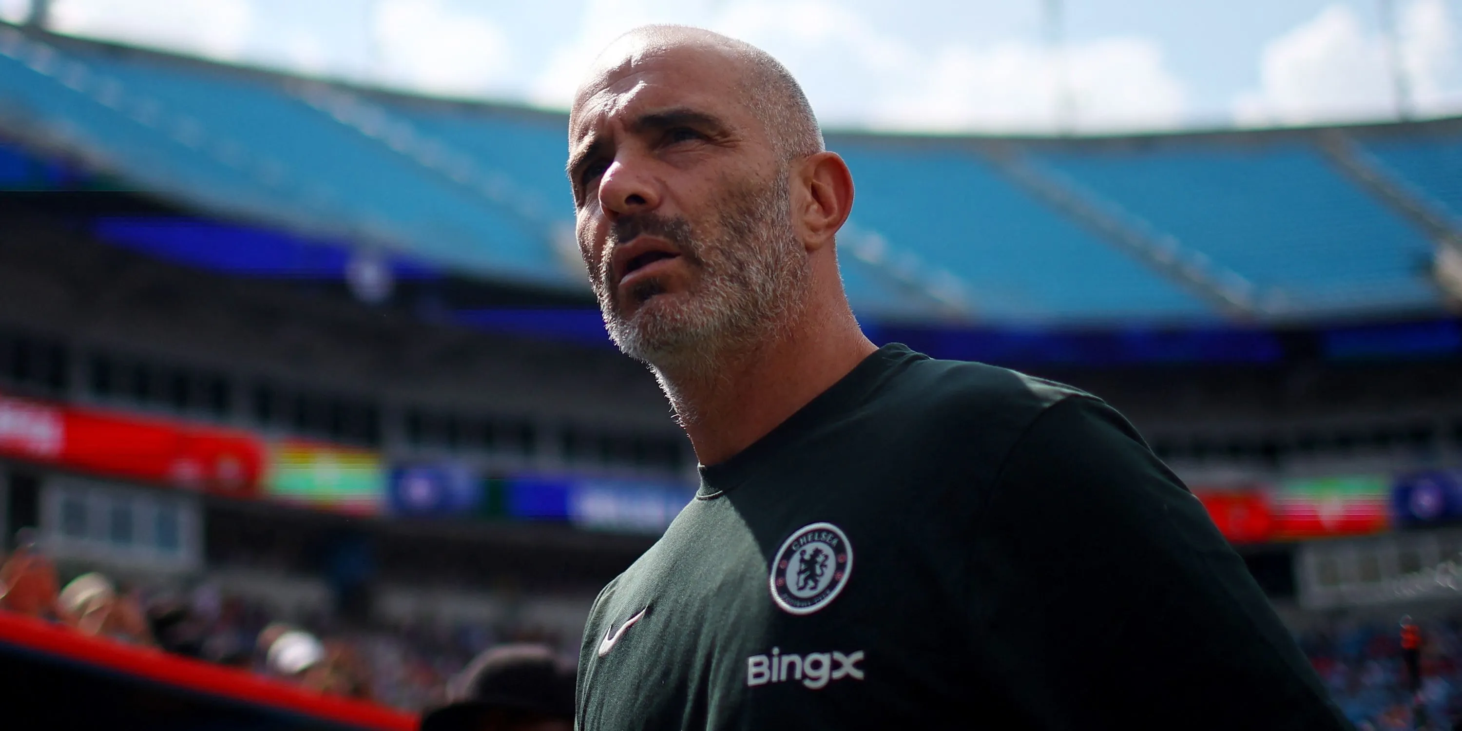 HLV Enzo Maresca của Chelsea đứng trên sân trước trận đấu, thể hiện sự tập trung vào các kế hoạch chuyển nhượng.